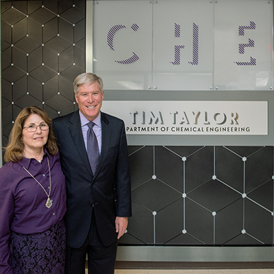 Tim and Sharon Taylor pose for a photo in front of department signage